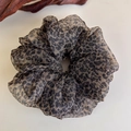 Close-up of leopard print chiffon hair scrunchie with soft pleated texture and semi-sheer fabric - Brown Black Leopard Translucent Chiffon (27333A)