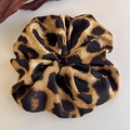 Close-up of leopard print scrunchie with silk texture on a minimalist wooden background - Brown Black Leopard Round Chiffon (27379B)