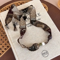 Detailed view of bohemian paisley fabric necklace with vintage beads on linen background - Green Paisley Scarf (27493D)