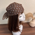 Detail view of brown floral headscarf tied in a bow on a mannequin head model - Brown Base Polka Dot Floral
