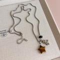 Macro view of star-shaped tiger eye pendant on a silver box chain sweater necklace - Star Pendant (27398D)