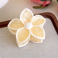Macro detail of cream marble resin flower hair claw with white edges on display tray - Beige Multicolor