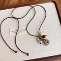 Détail d'un pendentif bohème en pierre avec perles en bois sur cordon ciré marron - Style à Pois (27412E)