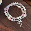 Elegantes zweilagiges Perlen- und Kristallarmband mit einem silbernen Schleifenanhänger - Rosa Weiß Schleife Stil