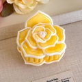 Detailed view of a yellow 3D camellia hair claw clip with acetate texture and white piping - Multicolor Gradient