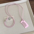 Nahaufnahme einer rosa Kamm-Halskette mit Silberperle und modischer Wachsschnur-Details - Rosa