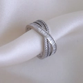 Dettaglio macro dell'anello intrecciato in argento con zirconi a taglio baguette e tondo - Aperto Regolabile / Argento