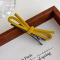 Detail view of ginger yellow velvet bow hair clip with a sturdy black metal duckbill base - Yellow