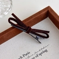 Detail view of a vintage dark brown velvet bow hair clip with a sturdy black metal duckbill clip - Brown