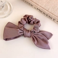 Dettaglio dell'elastico per capelli in raso malva con grande fiocco e finitura lucida - Rosa Loto