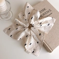 Dettaglio dello scrunchie beige a pois con etichetta A.L.M e ciondolo a cuore - Scrunchie Stile Sciarpa Quadrata con Fiocco a Pois (27463C)