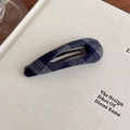 Dettaglio del fermaglio per capelli BB a quadri blu scuro su una pagina di libro - Goccia d'acqua / Ovale / Stile Goccia d'acqua Plaid Blu Marino
