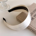 Close-up of pearl white satin headband with non-slip teeth on vintage book background - Off White
