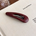 Close-up of wine red faux leather hair clip with crocodile skin texture on a book - Red Teardrop BB Clip (27459E)