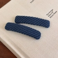 Detalle de dos pinzas para el cabello BB rectangulares de punto azul marino en un libro - Azul