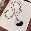 Dettaglio di una collana con ciondolo ad anello in legno con texture argento martellato - Base Argento Legno Nero