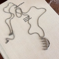 Collar de plata con colgante de peine sobre libro, accesorio minimalista de moda - Peine Plateado con Cadena de Serpiente