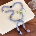 Gedetailleerde macro-opname van handgemaakte blauwe gebreide ketting met gekleurde kralen - Blauw Garen (27503C)