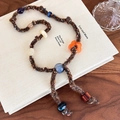 Detail van bohemien gebreide kralenketting met bruin wollen touw op een sierboek - Koffie Garen (27503D)