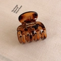 Close-up of amber tortoiseshell hair claw clip with golden Barrette LaFrance lettering - Leopard Small Multi-tooth