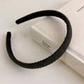 Detail of dark green woven knit headband with ribbed texture on a vintage book - Green