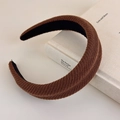 Close-up of brown knitted sponge headband with textured vertical stripes and soft fabric - Brown