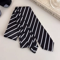 Dettaglio di cravatta in raso a righe bianche e nere con eleganti accessori business - Stile a Righe Bianco e Nero (27316C)