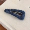 Detailed view of handmade navy blue yarn-wrapped triangular hair clip with colorful specks - Blue