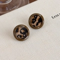 Vue macro détaillée de boucles d'oreilles léopard avec bords en résine vintage - Style Rond Marron