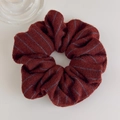 Macro shot of knitted burgundy hair scrunchie with blue stripes and soft woolen texture - Hair Tie / Red