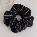 Detail of black knitted scrunchie with white stripes showing soft texture and cozy knit fabric - Hair Tie / Black