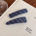 Detail of two knitted plush hair clips with blue and grey stripes on an aesthetic book background - Blue Diagonal Stripe (27529B) / Blue