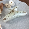 Détail de la pince à cheveux marbrée avec étoile de mer en strass et coquillages - Blanc Irisé