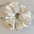 Vue macro détaillée des bords volantés et de la texture satinée soyeuse de ce chouchou crème - Style à Volants en Satin Blanc Laiteux (26357A)