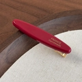 Dettaglio del fermaglio per capelli in acetato rosso scuro con scritta oro France Handmade - Borgogna