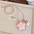 Vue détaillée du collier étoile rose avec texte gravé et breloque fleur sur un plateau - Étoile Rose