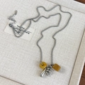 Detail of grape cluster pendant necklace with yellow stones and silver drops on tray - Coffee Style (26928C)