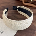 Dettaglio del cerchietto intrecciato beige con fodera antiscivolo nera su vassoio di legno - Beige