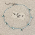 Detail of blue cord necklace with transparent teardrop pendants and adjustable silver clasp - Blue