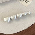 Dettaglio di cinque cuori di perle su un fermaglio per capelli argento minimalista - Cuore Bianco