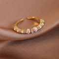 Primer plano de un anillo ajustable dorado con un lazo de esmalte rosa y una perla - Abierto Ajustable / Estilo Dorado (26974A)