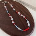 Collana di perline in stile etnico con perle rosse blu e cristalli su vassoio in legno - Stile Principale