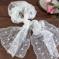 Elegante sciarpa in pizzo bianco con ricami floreali e bordi ondulati su legno scuro - 140cmx33cm / Bianco