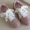 Detail of pink suede sneakers with elegant white lace shoelaces tied in a bow - White