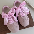 Detail view of pink suede sneakers featuring wide silk ribbon laces tied in a bow - 120cm / Pink Style (27051B)