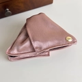 Detailed close-up of pink satin fabric hair clip with engraved golden metal button - Pink