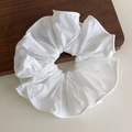 Close-up detail of a large white ruffled scrunchie on a minimalist wooden surface - White Style (27067A)