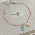 Detalle del collar de cordón rosa con colgante de pez de concha y cuentas de colores - Cordón Rosa
