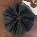 Macro shot of large black pleated scrunchie with sheer organza texture on wood - Black