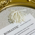 Detailed view of elegant white pearl shoe charms arranged on a romantic vintage prop - White Faux Pearl Tassel Style (27059-22)
